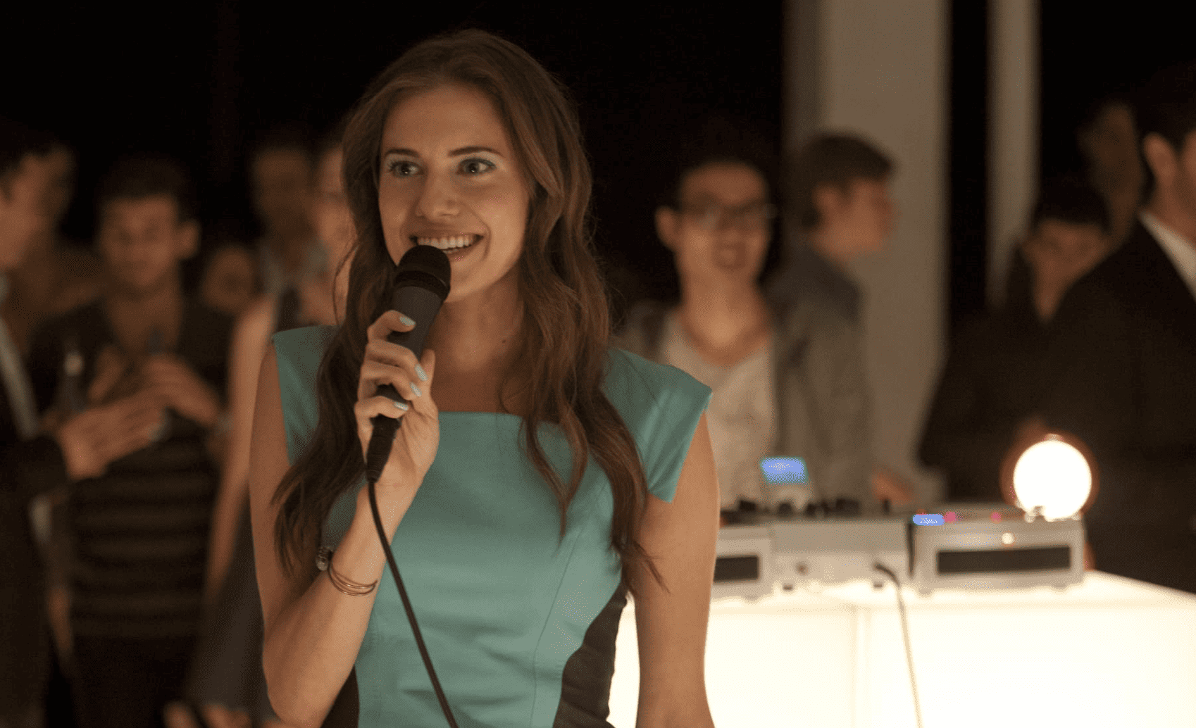Marnie standing on a dance floor, ready to sing in this image from Apatow Productions