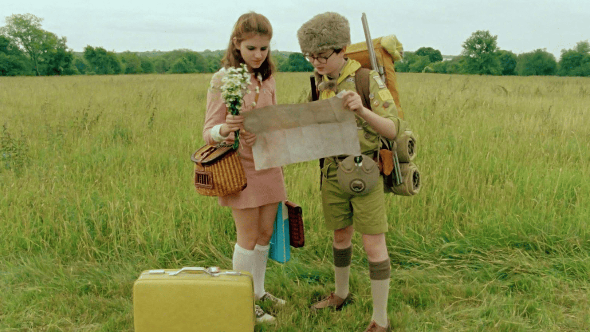 Kara Hayward and Jared Gilman stand in a field and look at a map in this image from Indian Paintbrush