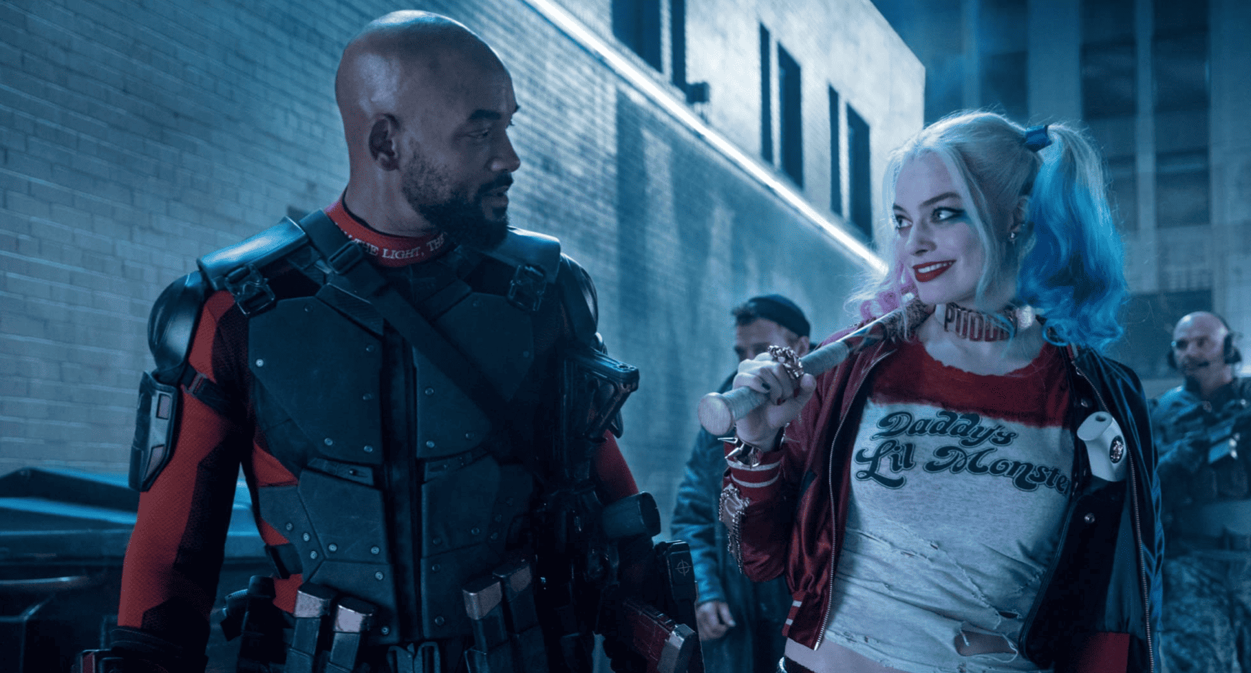 Margot Robbie as Harley Quinn gives a side look to Will Smith’s Deadshot in this image from DC Entertainment