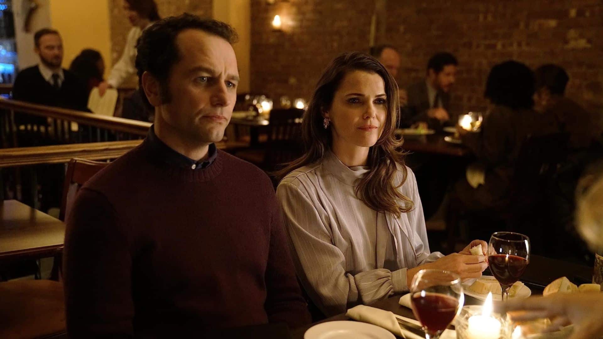 Matthew Rhys and Keri Russell sit in a restaurant in this image from FX Networks.
