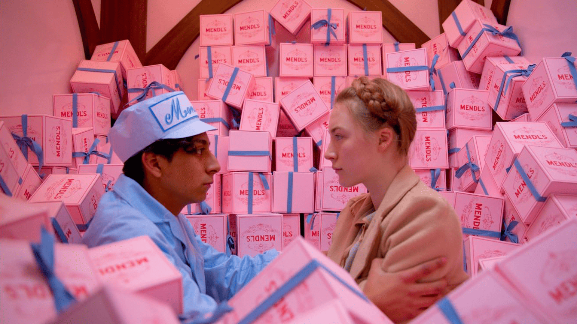 Tony Revolori and Saoirse Ronan sit in a pile of pink Mendl’s Bakery boxes in this image from Indian Paintbrush