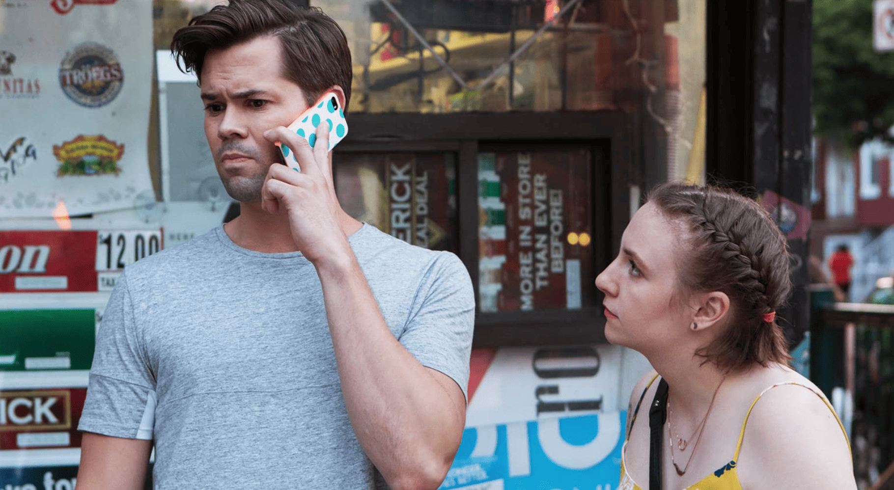 Elijah talking on the phone next to Hannah in this image from Apatow Productions