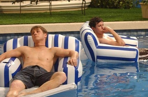 Two men lounge in the pool in this image from Warner Bros. Studios