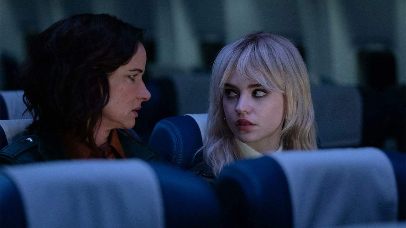 Two women look at each other while sitting on a plane in this image from Showtime Networks.