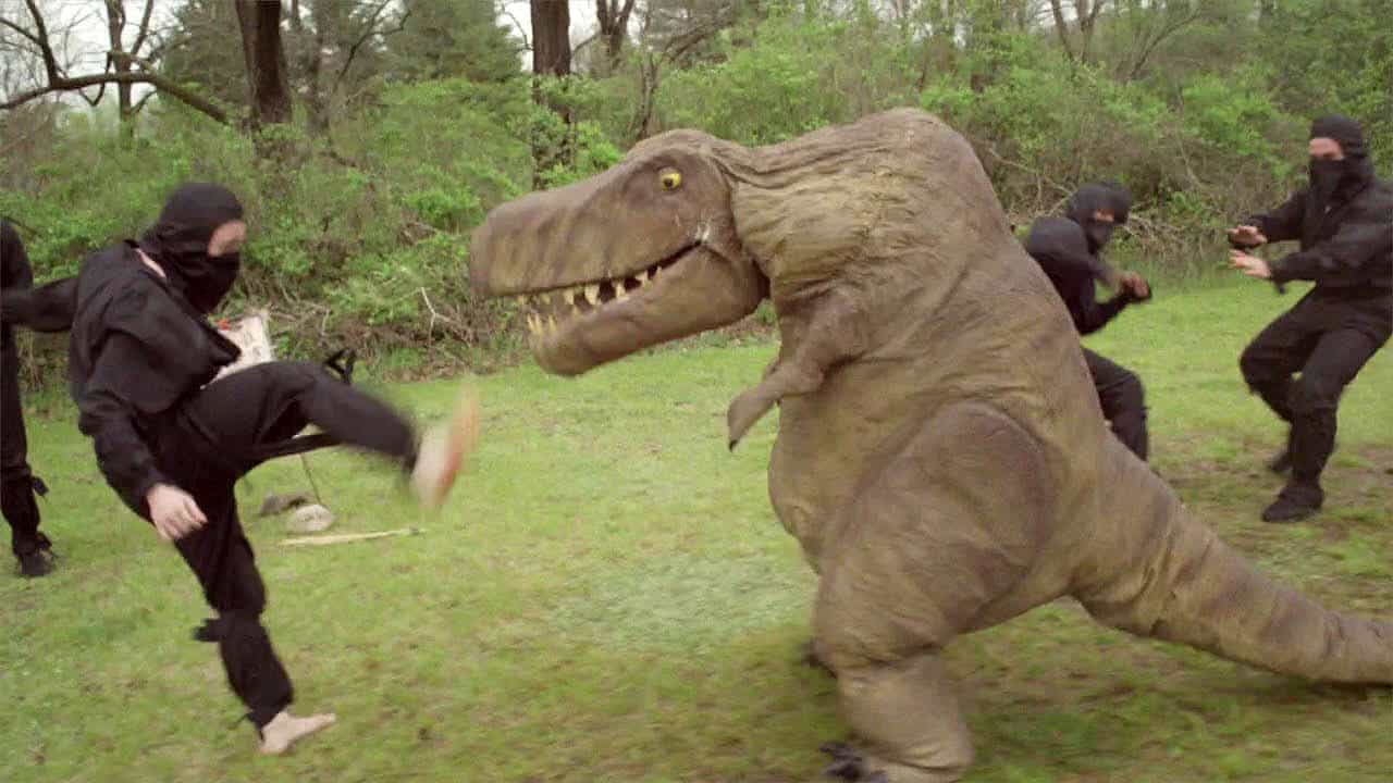 Ninjas fighting a person in a velociraptor costume in this image from Hollow Tree Films