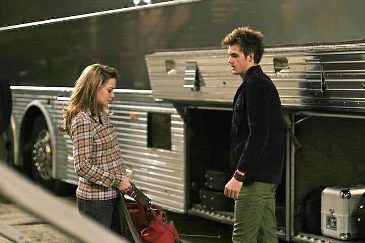 A woman and man stand outside a tour bus in this image from Tollin/Robbins Productions