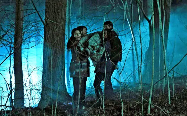Four college students carry a rug-wrapped body through a dark forest in this image from Shondaland