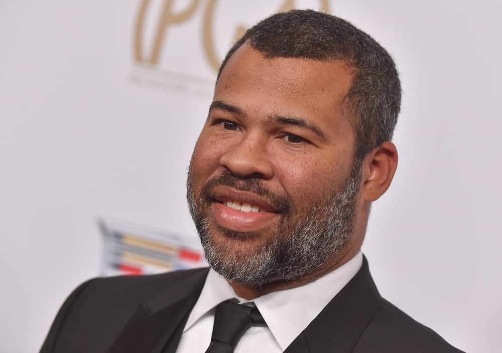 Jordan Peele smiling at a press event in this image from Shutterstock
