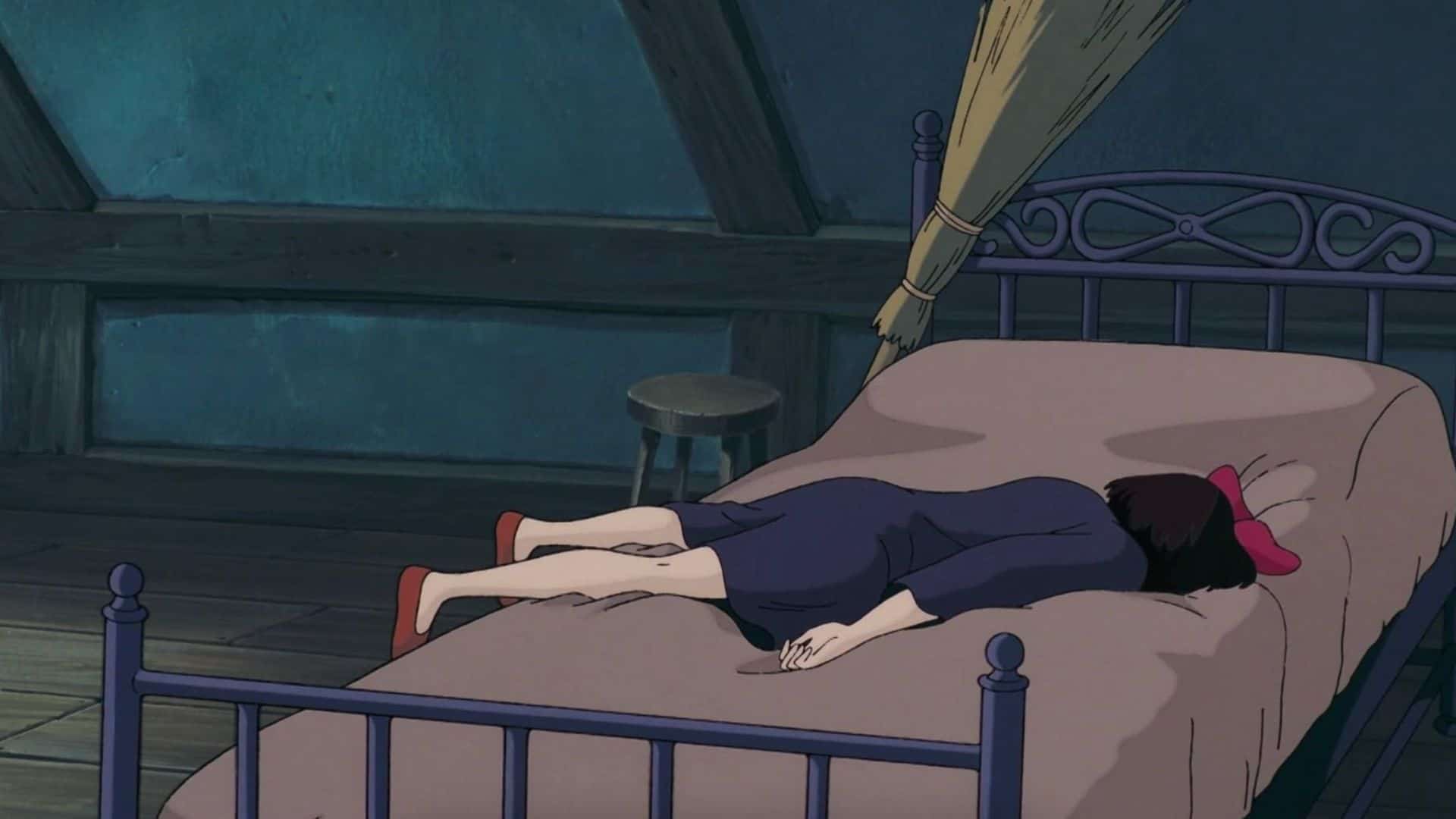 Kiki lies face-down on her bed in this image from Studio Ghibli