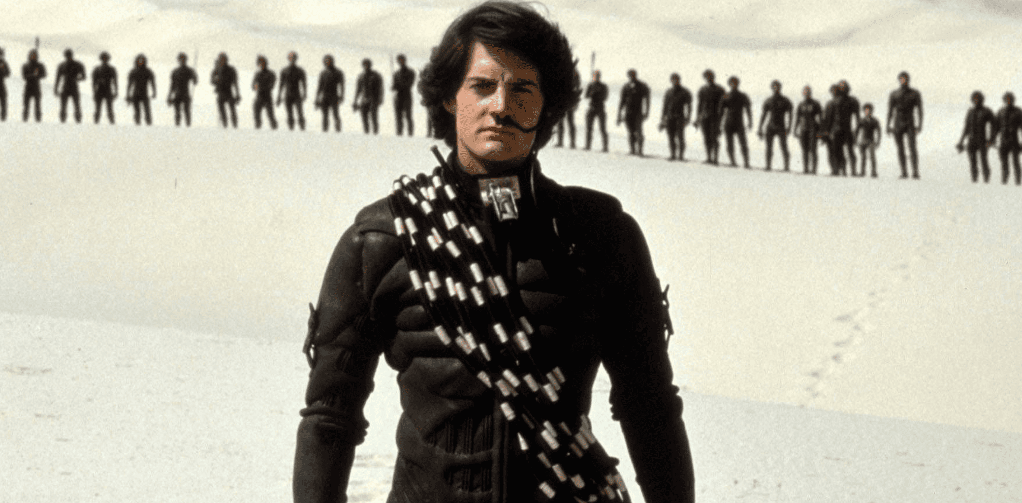 Paul Atreides stands in the desert while in uniform in this image from Dino De Laurentiis Company.