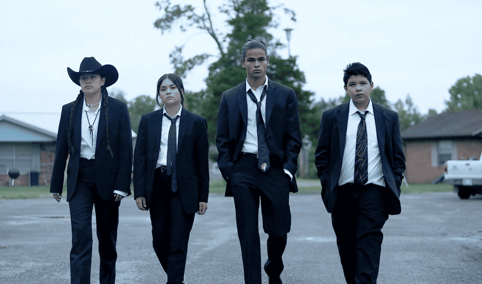 Four kids walk down the street dressed in suits in this image from FXP