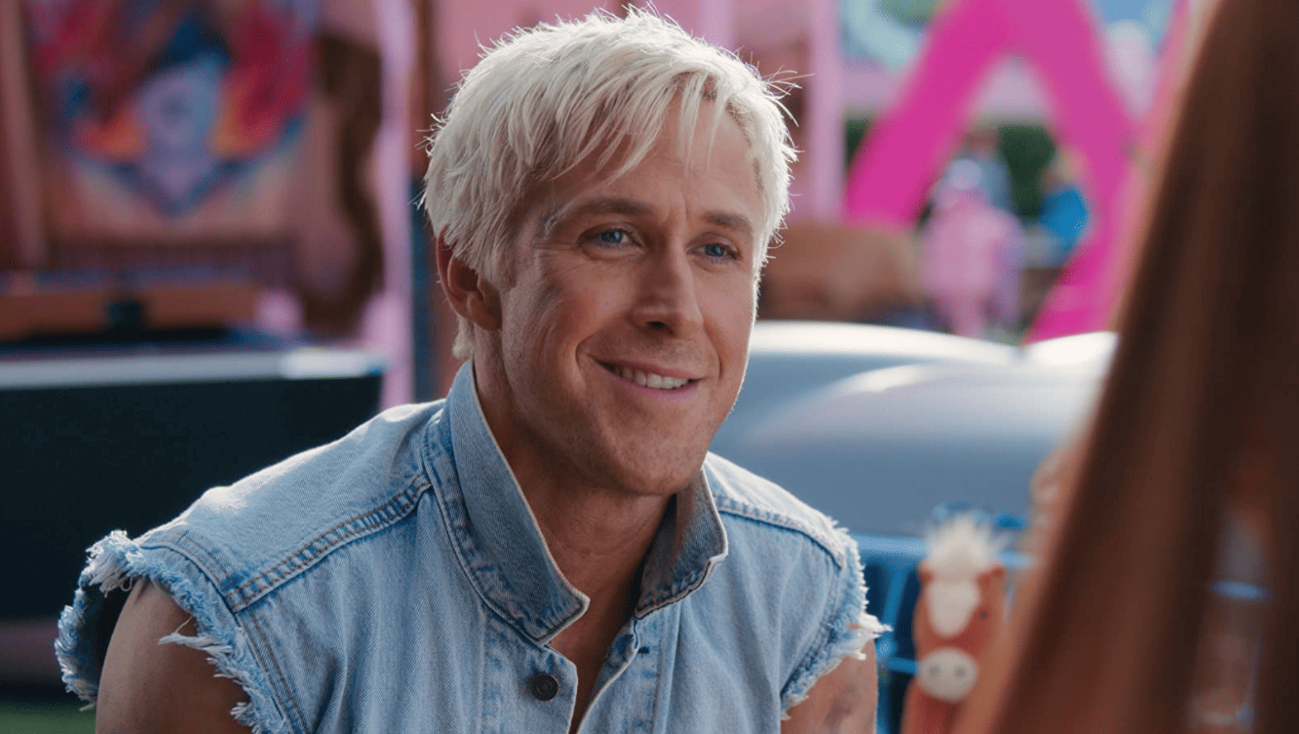 A close-up of Ryan Gosling as Ken with his hair bleached and some squint lines showing in this image from Warner Bros