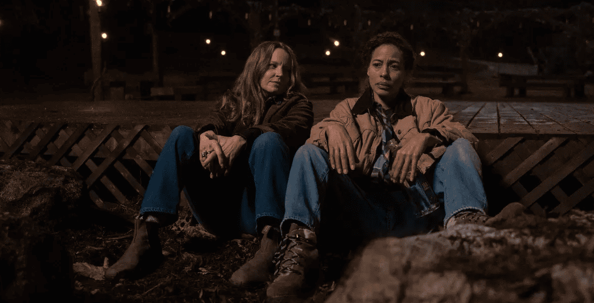 Two women sit next to each other outdoors in this image from Showtime