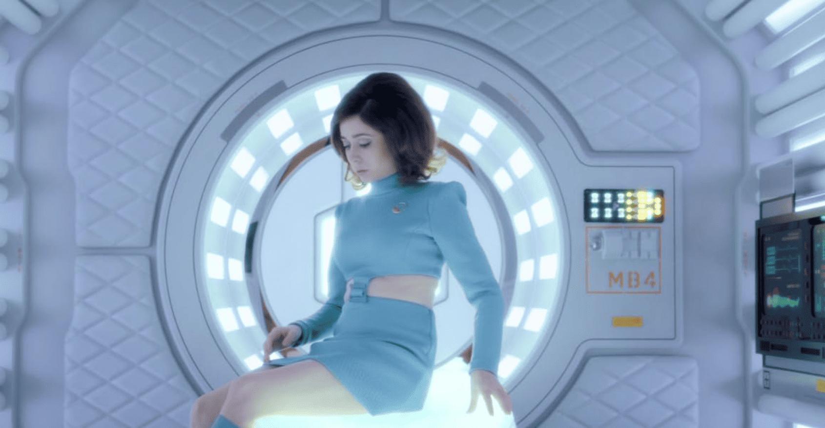 Cristin Milioti wears a light blue uniform, getting up from what appears to be an X-ray machine in this image from Zeppotron.