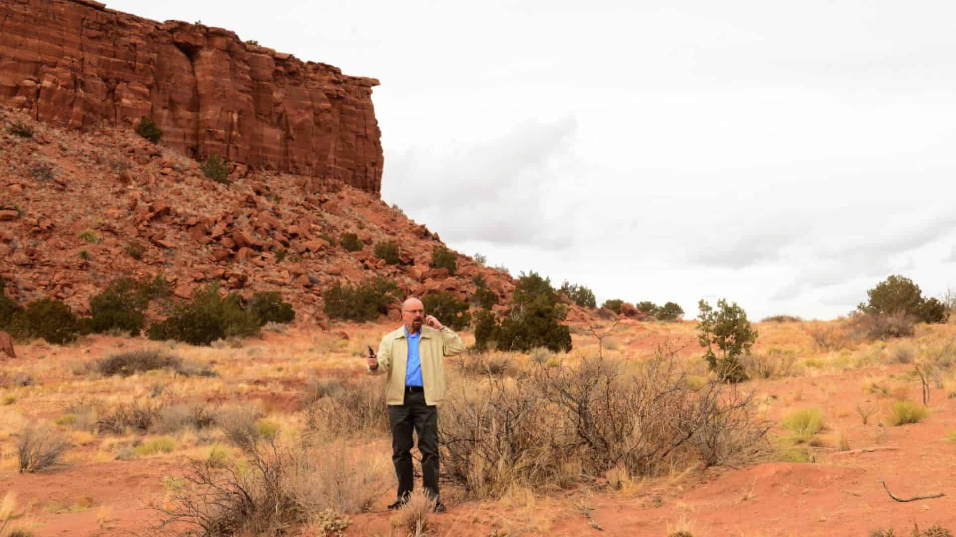 Bryan Cranston holding a cell phone and gun in the desert in this image from Sony Pictures Television