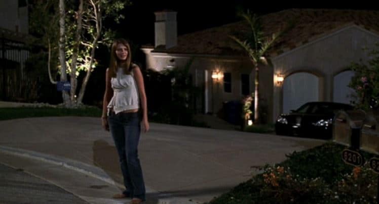 A woman stands in a driveway in this image from Warner Bros. Studios