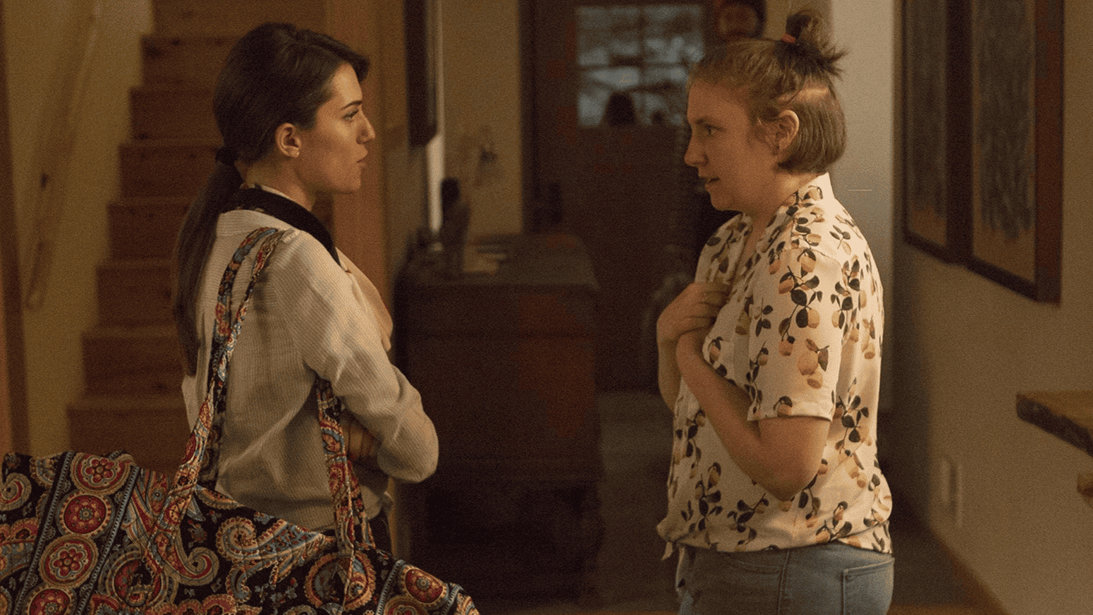 Marnie and Hannah stand in a hallway facing each other in what seems to be a tense conversation in this image from Apatow Productions.