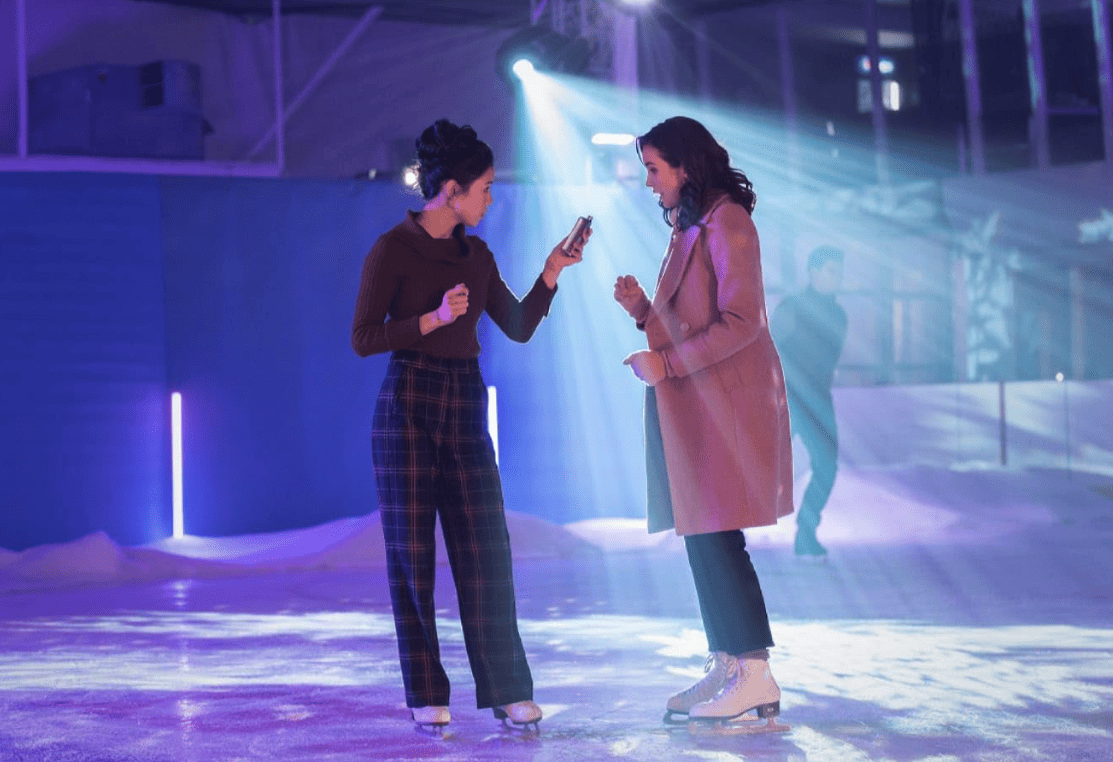 Two girls share a flask while ice skating in this image from CBS Television Studios.