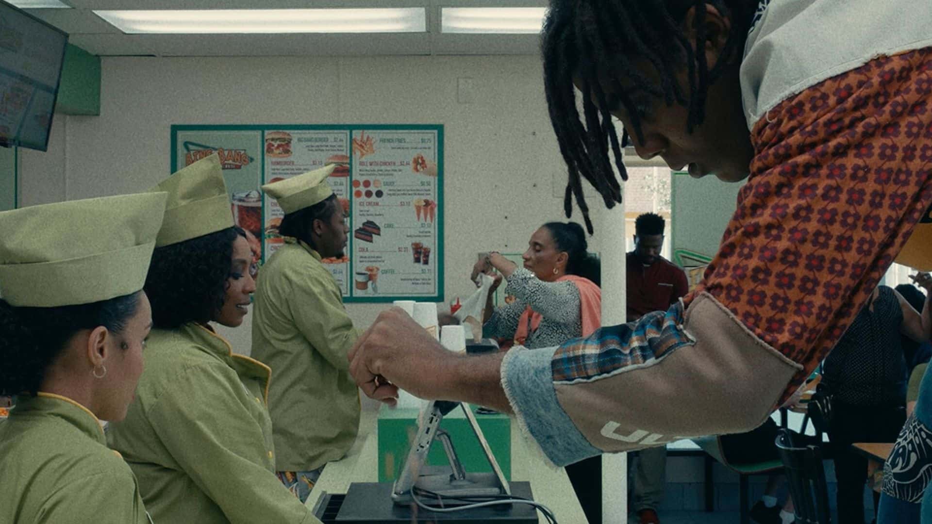 Olivia Washington takes payment from Jharrel Jerome over a fast food counter in this image from Amazon Studios.