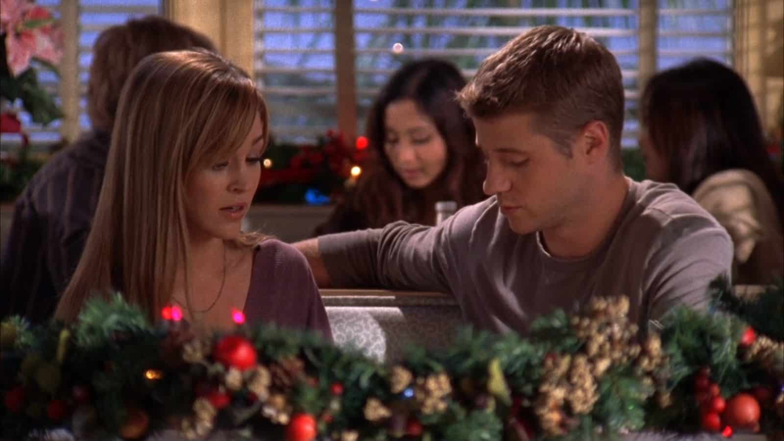 A couple sits in a restaurant booth decorated with garland in this image from Warner Bros. Studios