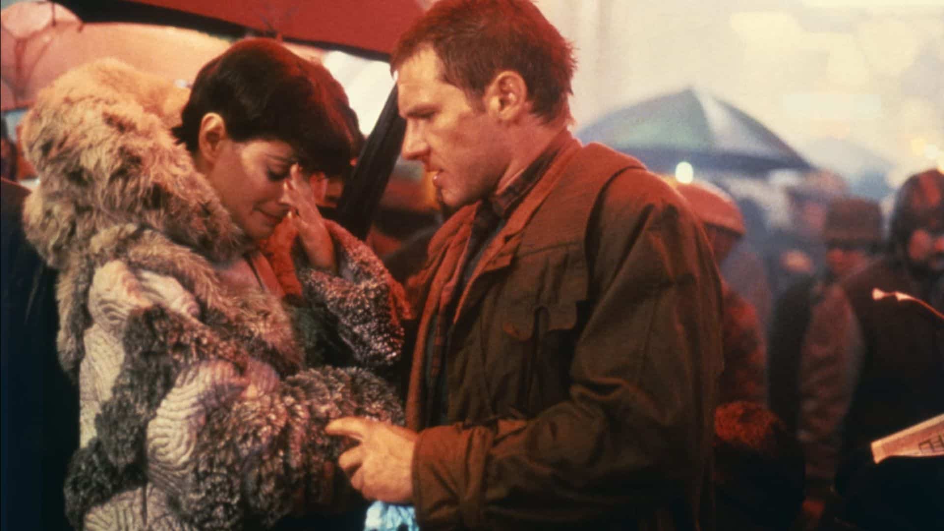 Sean Young in a fur coat standing with Harrison Ford in this image from The Ladd Company