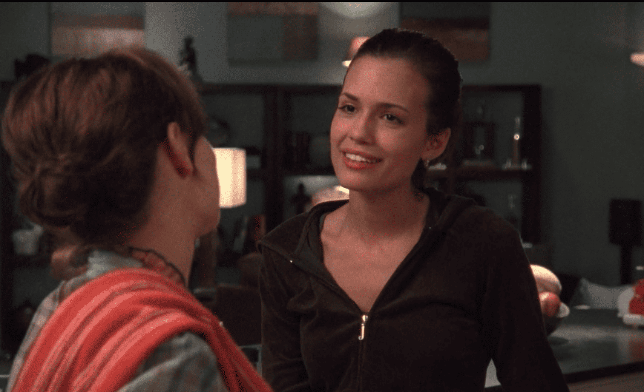 A woman talks to another woman in a kitchen in this image from Tollin/Robbins Productions