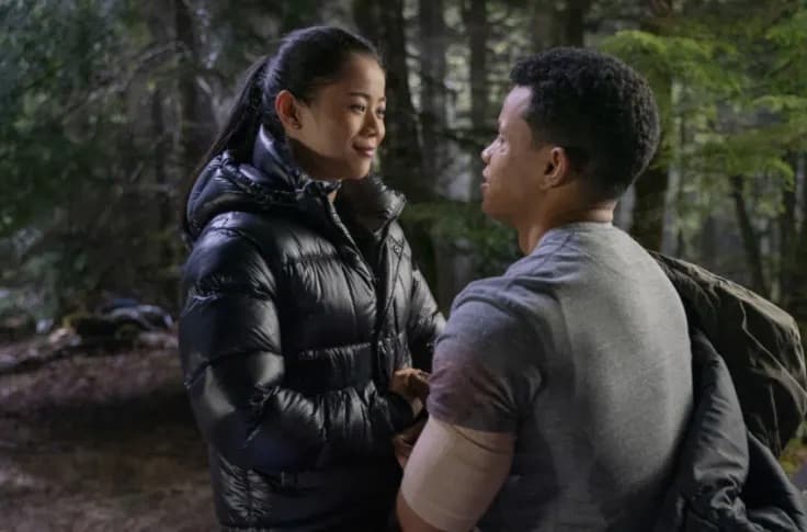 A man kneels before a girl in the forest in this image from CBS Television Studios. 