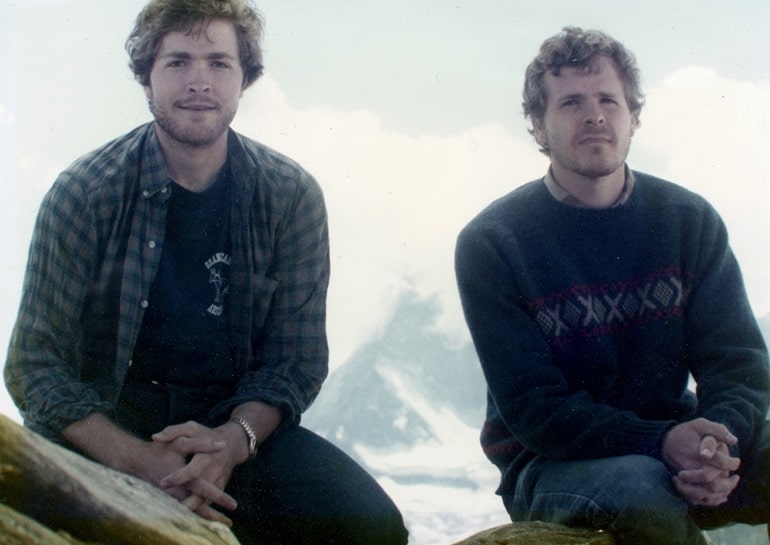 Two brothers in the 1980s with sweaters and flannels take a break from a hike in this image from ABC News Studio.
