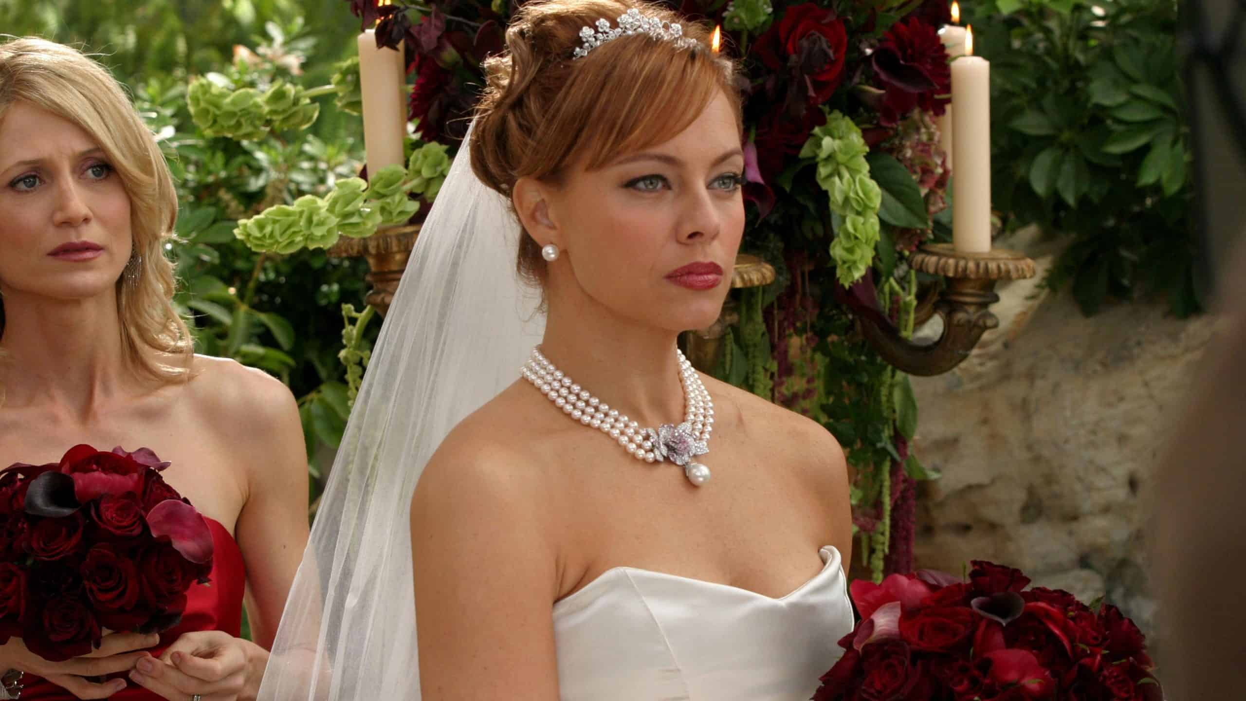 A woman holding flowers stands behind a bride in this image from Warner Bros. Studios.