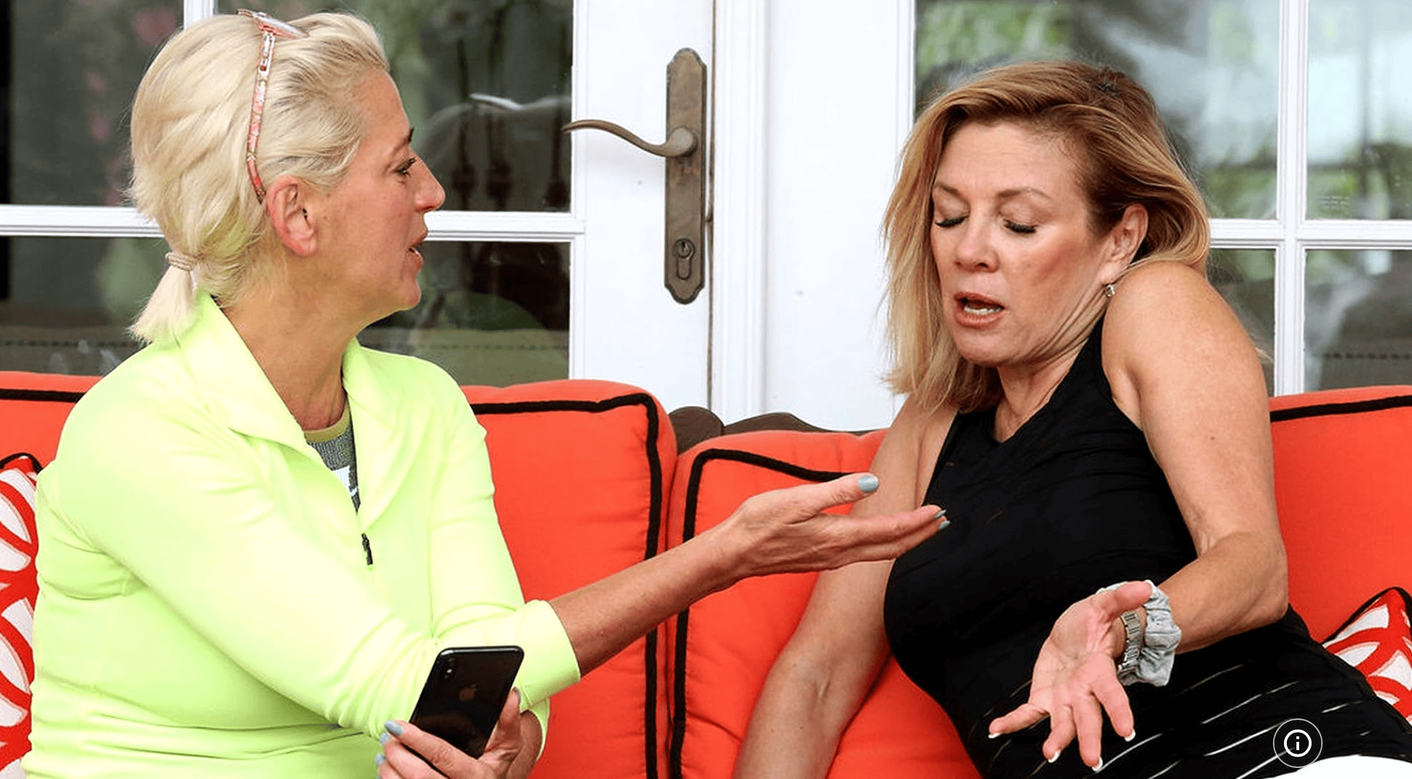 Dorinda Medley and Ramona Singer sitting on a bench wearing athletic clothes and having an impassioned conversation in this image from Ricochet Television