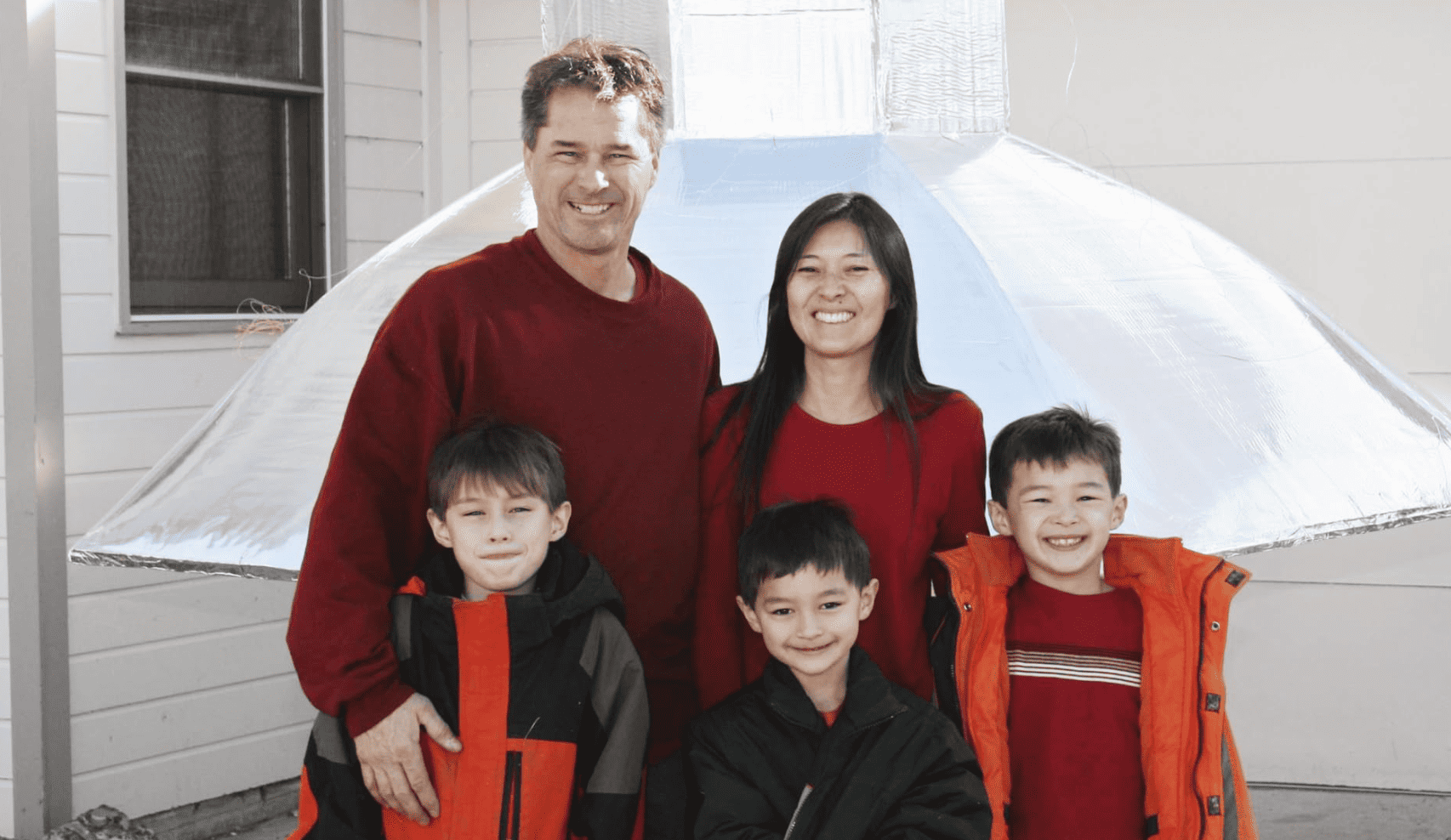 A family poses outside their home before the wife goes to another family in this image from Banijay Studios North America.