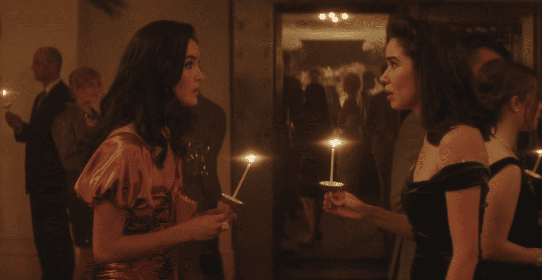 Two girls at a cocktail party holding lit candles in this image from CBS Television Studios.