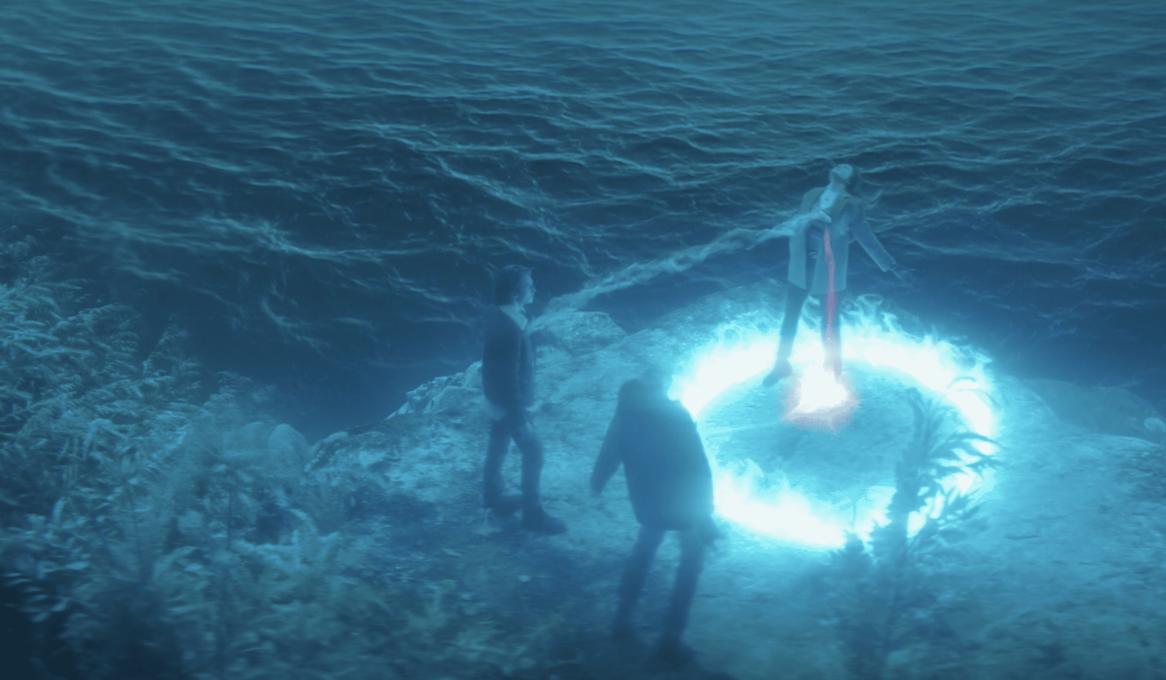 Three people’s souls getting sucked in a ring of blue light in this image from CBS Television Studios