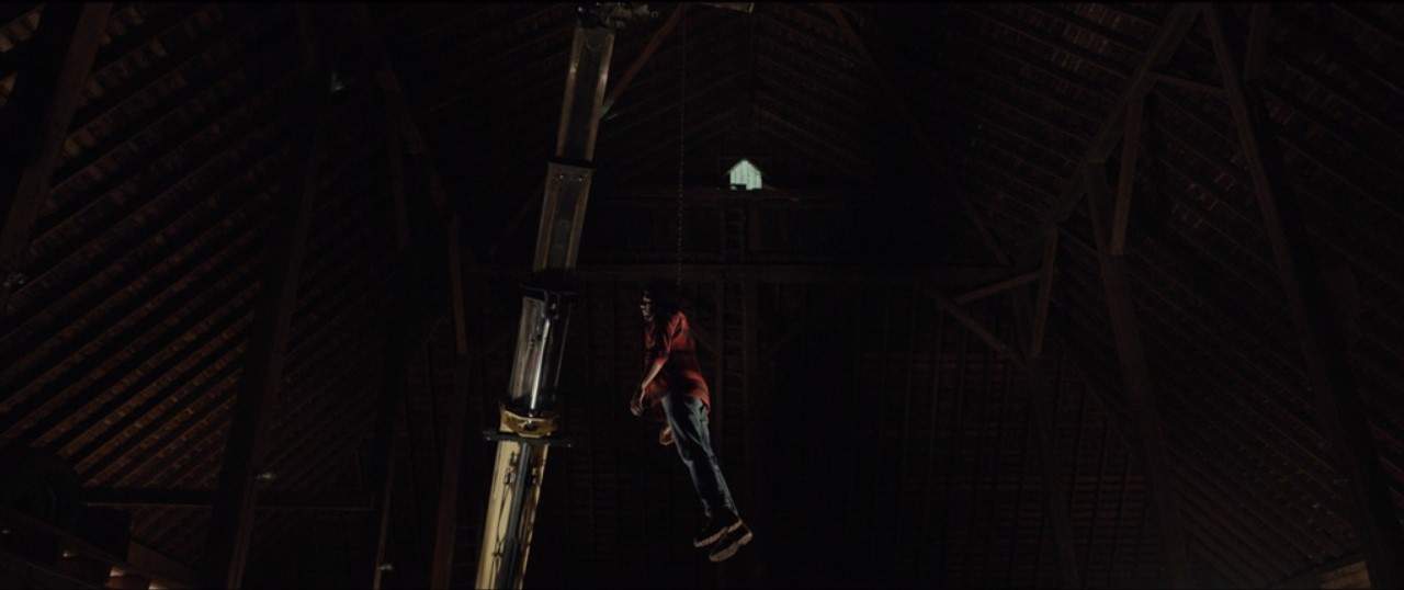 A dead man hangs in the air attached to farm equipment in this image from Showtime.