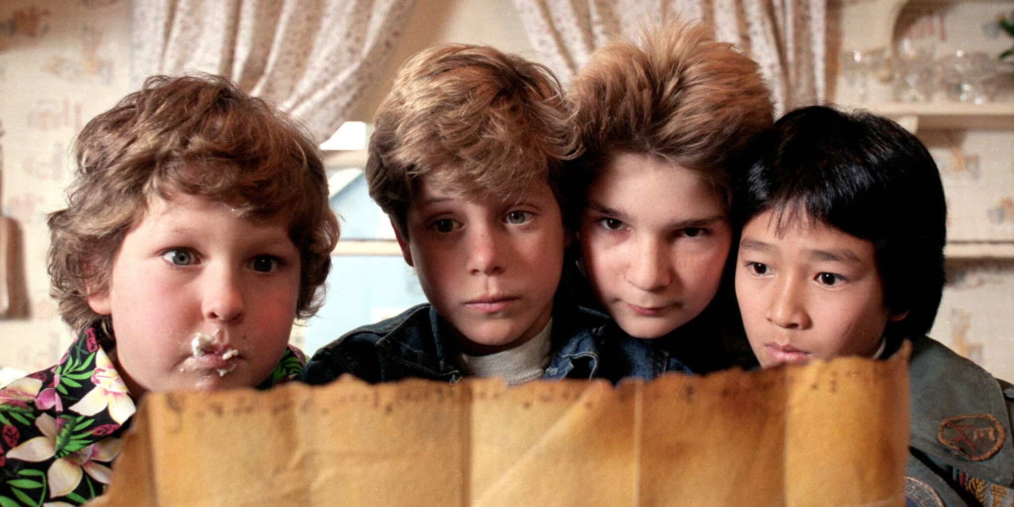 Four young boys look at a map in this image from Amblin Entertainment.