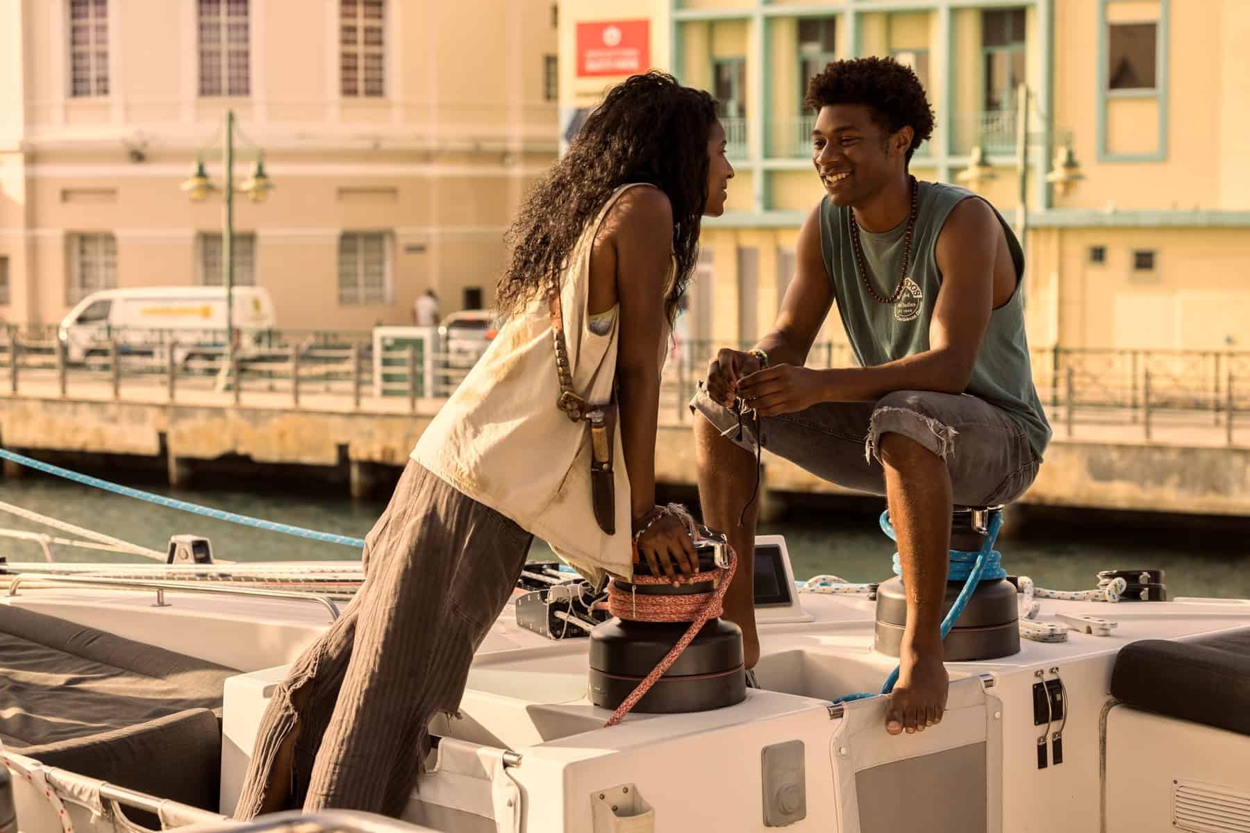 A young woman leans in toward a young man sitting on a boat in this image from Red Canoe Productions.