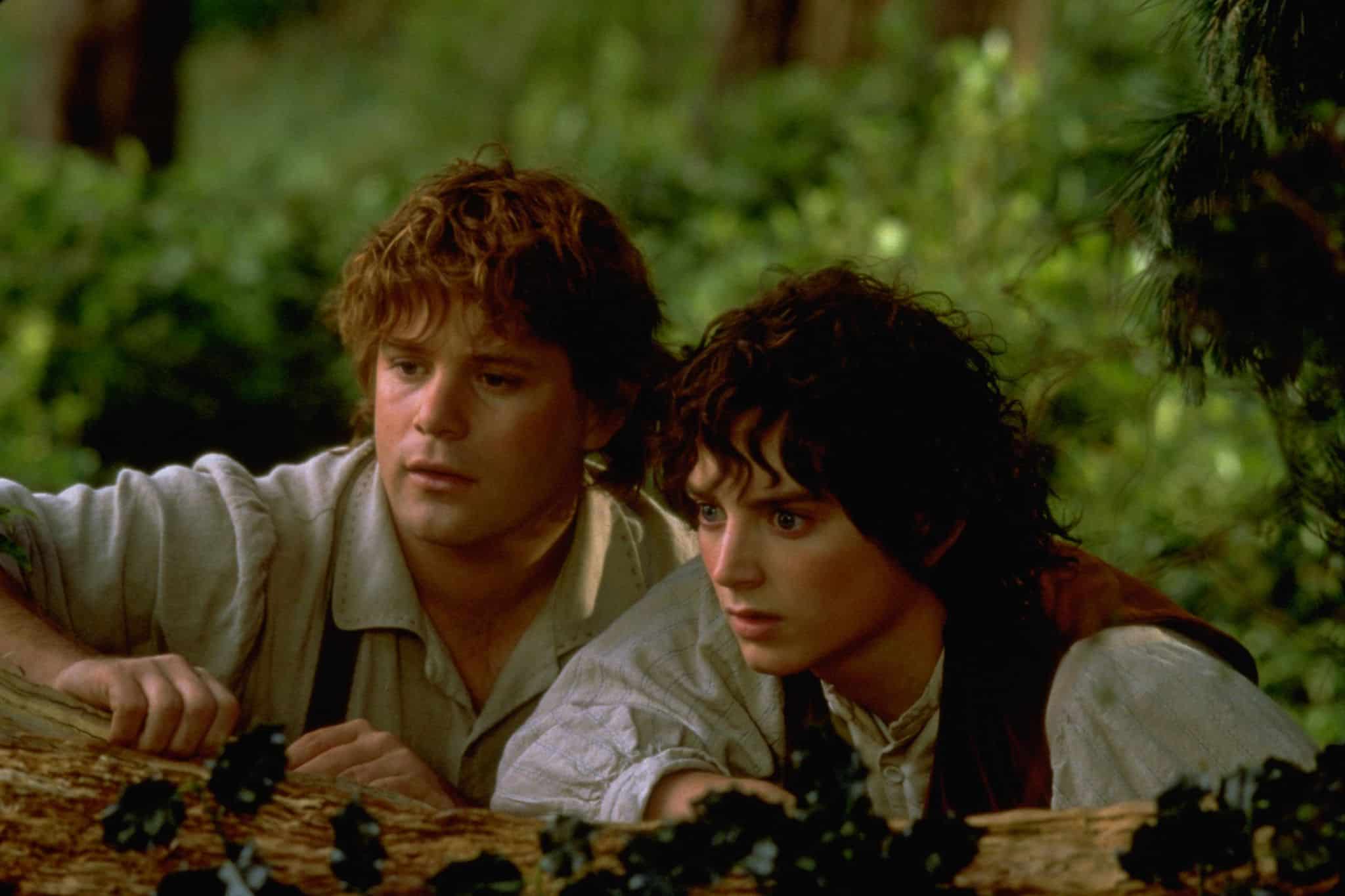 Sean Astin and Elijah Wood hide behind a tree branch in this image from New Line Cinema.