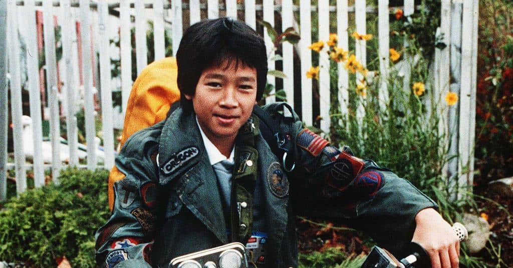 A young Ke Huy Quan sitting on a bike in this image from Amblin Entertainment.