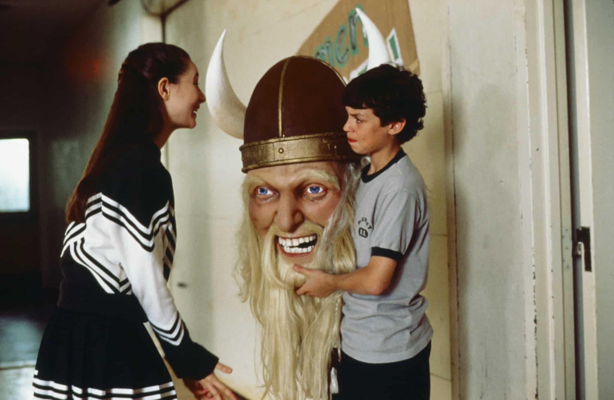 A young girl talks to a boy holding a mask in a school hallway in this image from DreamWorks Television.