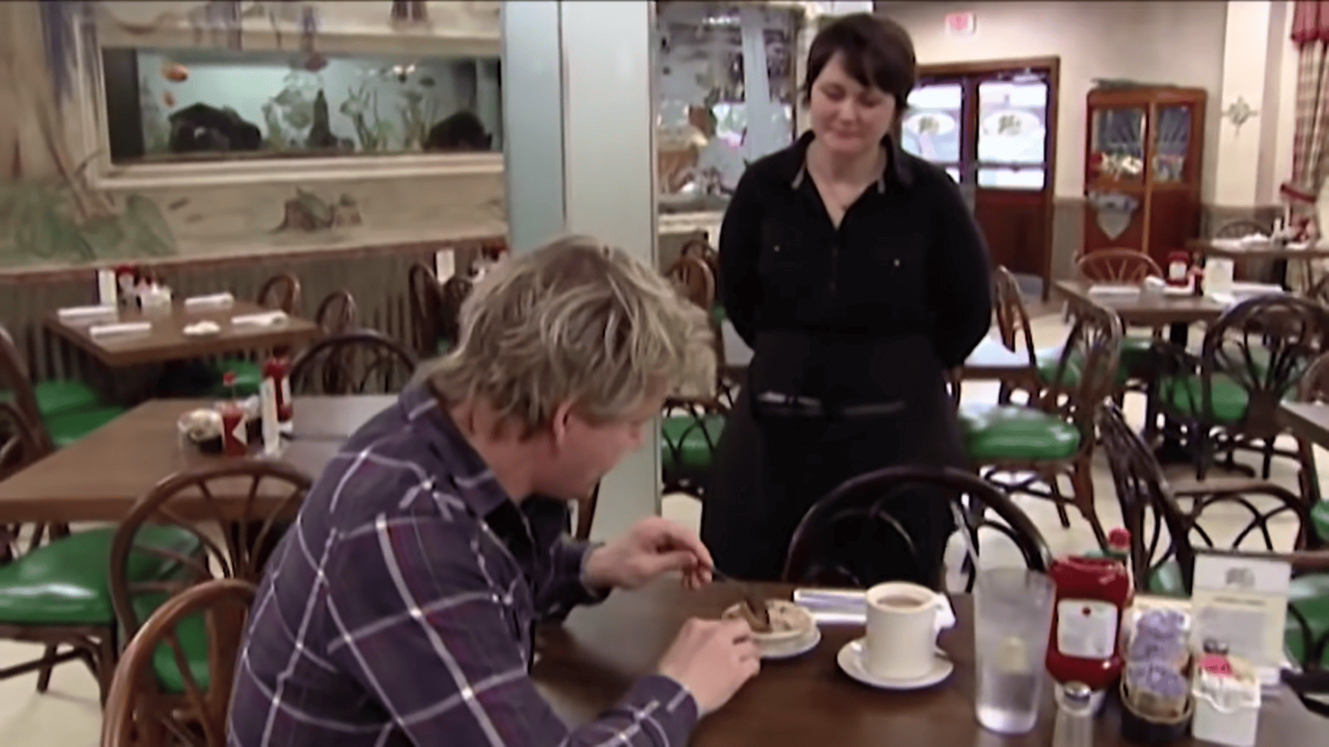 Ramsay trying bread pudding served by waitress Candace in this image from Studio Ramsay Global