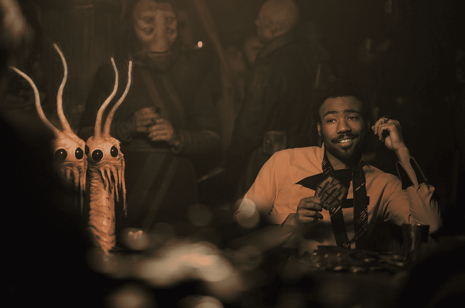 Lando plays card games in a dimly lit bar in this image from Lucasfilm.