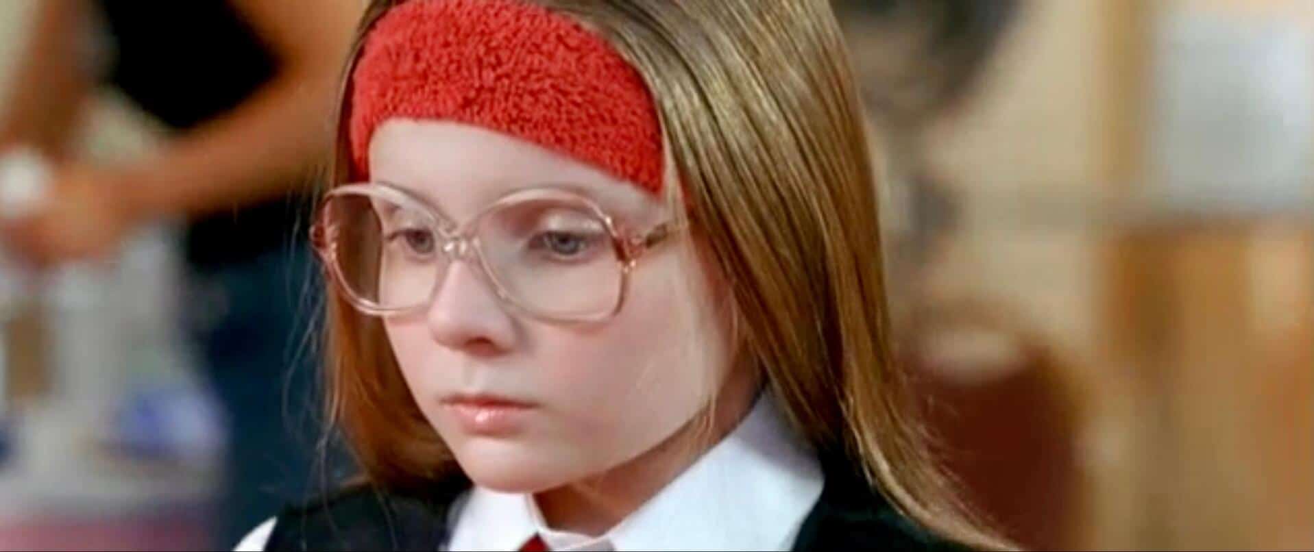 A young girl wearing glasses looks down in this image from Big Beach Films.