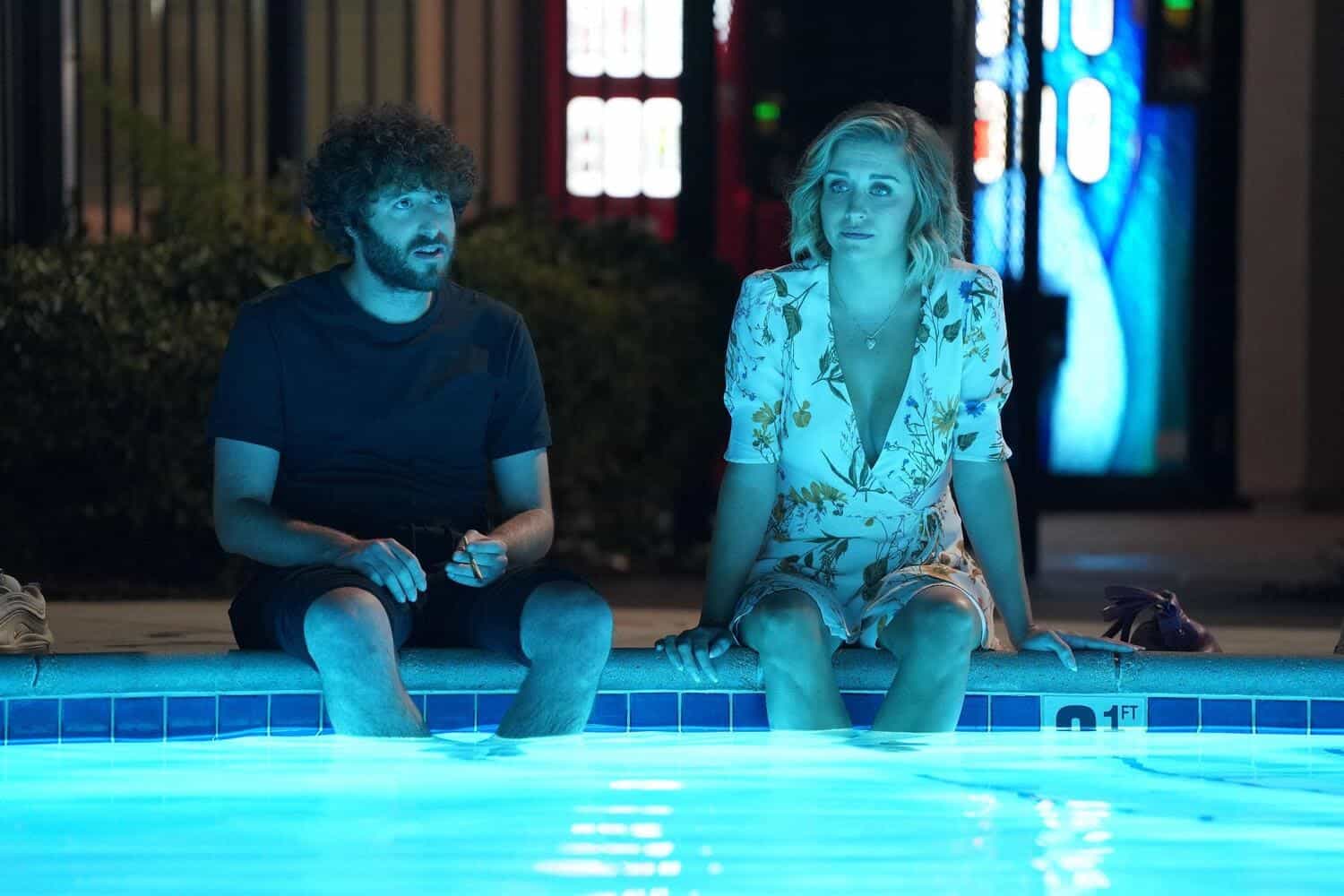 A man and woman sit with their feet in a pool in this image from FX Productions.