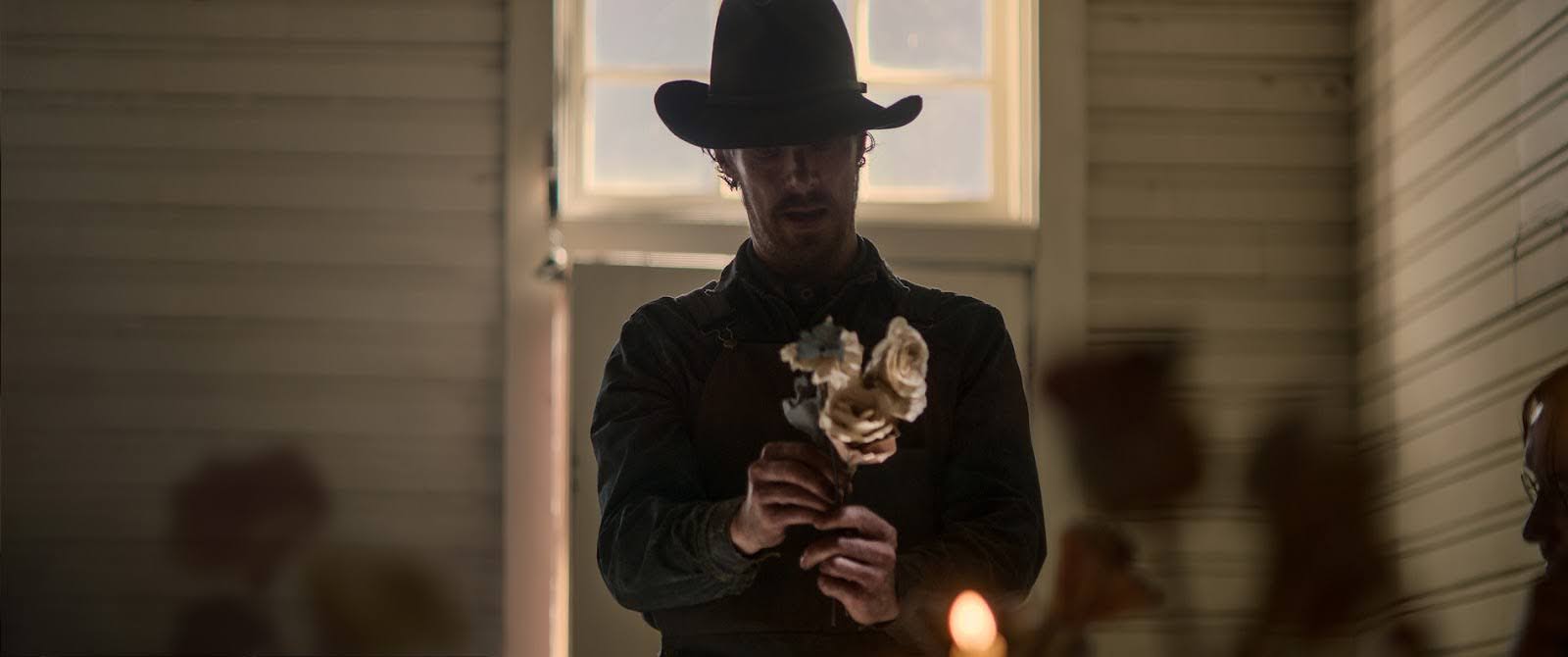  A man in a cowboy hat holds a small bouquet of white roses in this image from See-Saw Films.