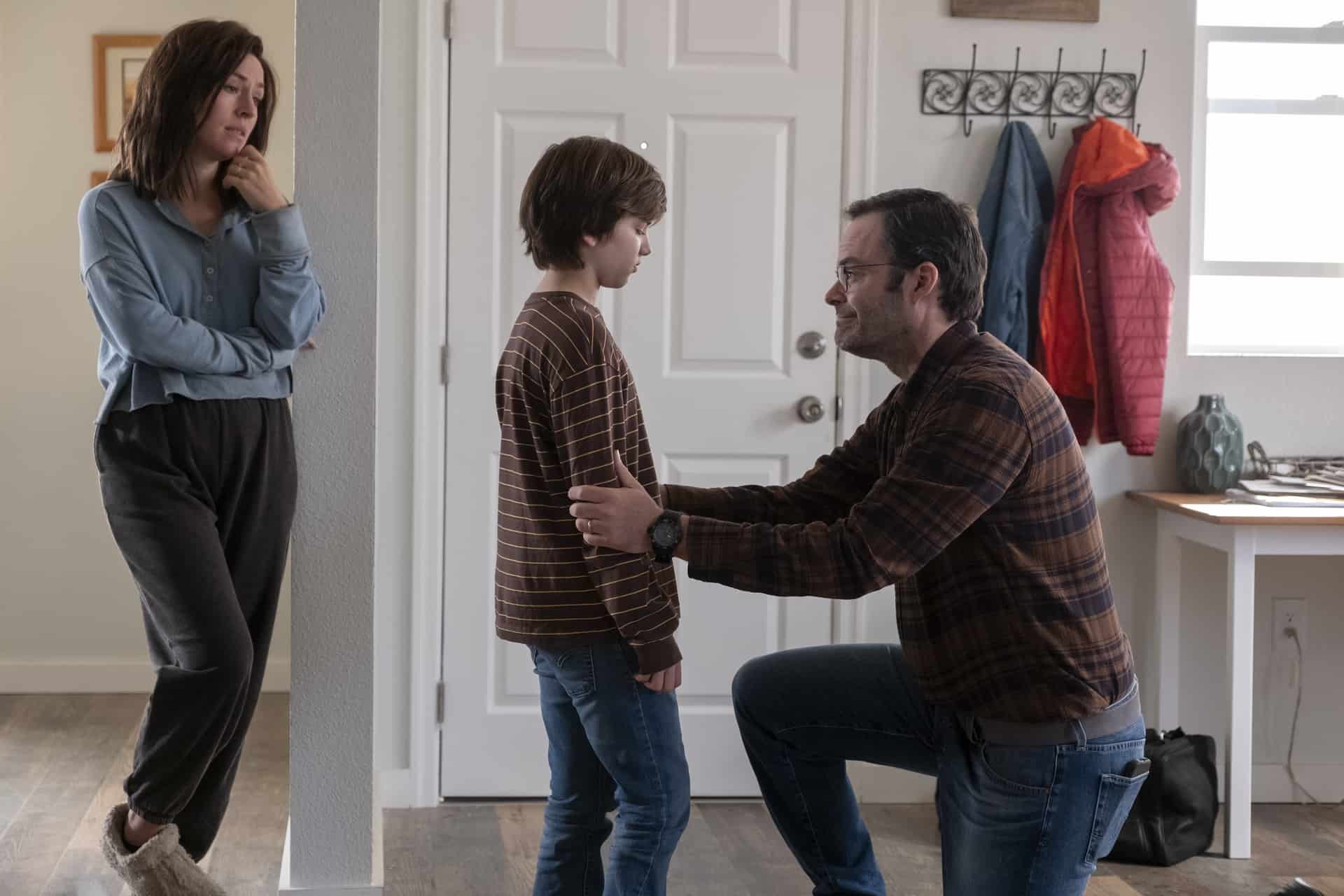 A man kneels in front of a young boy while a woman looks on in this image from HBO Entertainment.