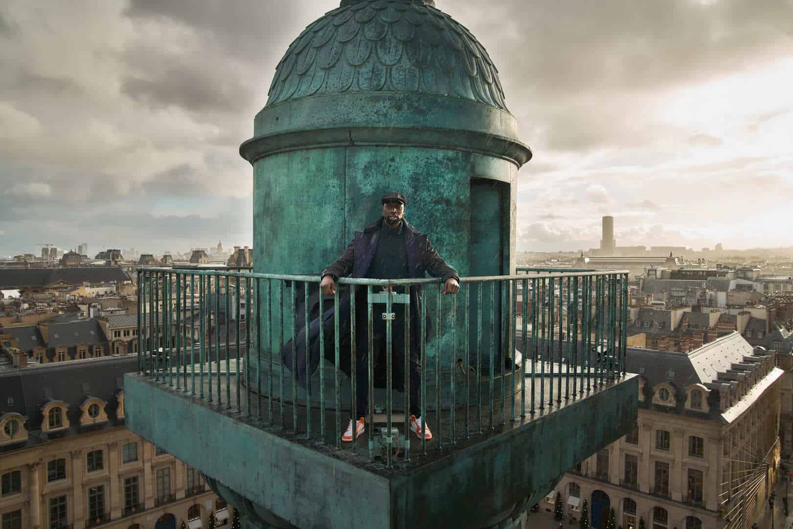 A man stands atop a Parisian tower in this image from Gaumont Télévision.