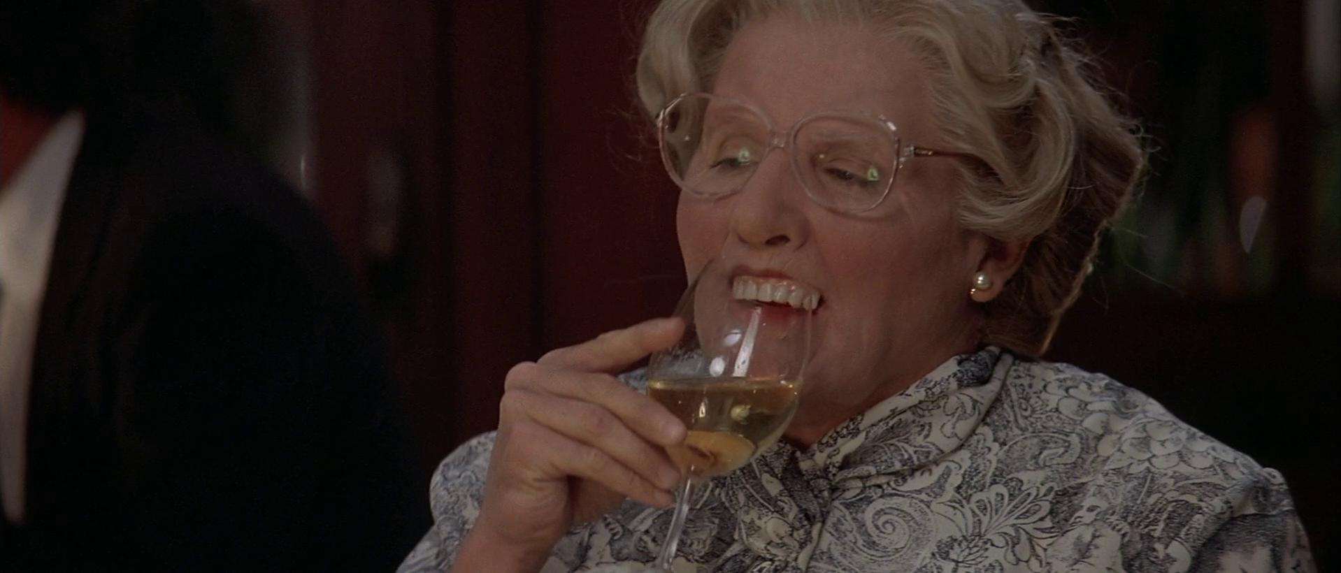 A man dressed as an old woman and drinking wine in this image from Twentieth Century Fox.