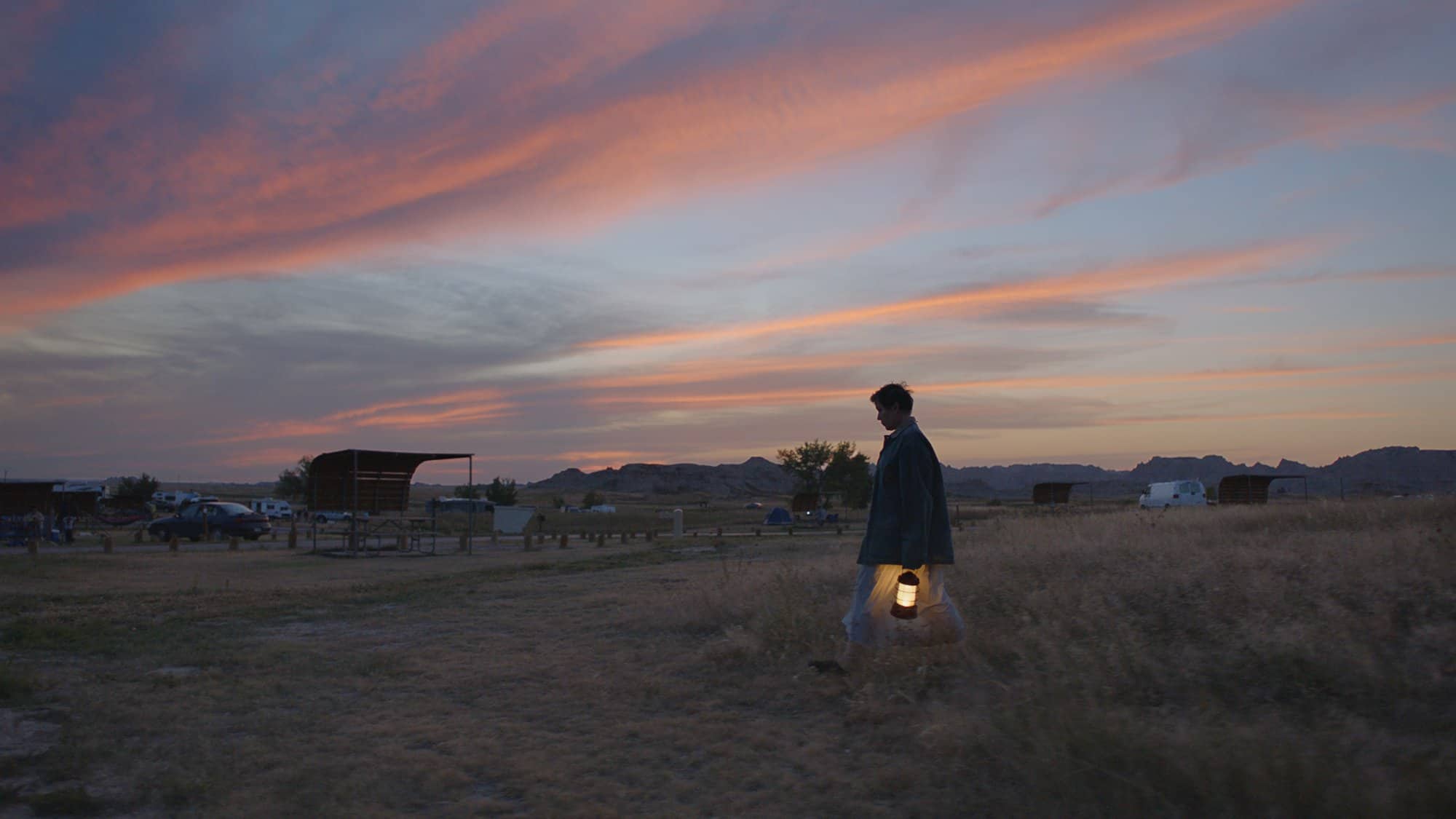 A person carries a lantern at sunrise in this image from Hear/Say Productions. 