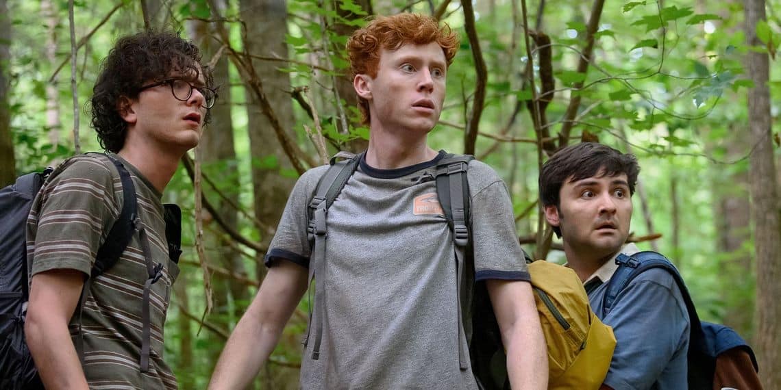 Three men look concerned in the woods in this image from Apatow Productions.