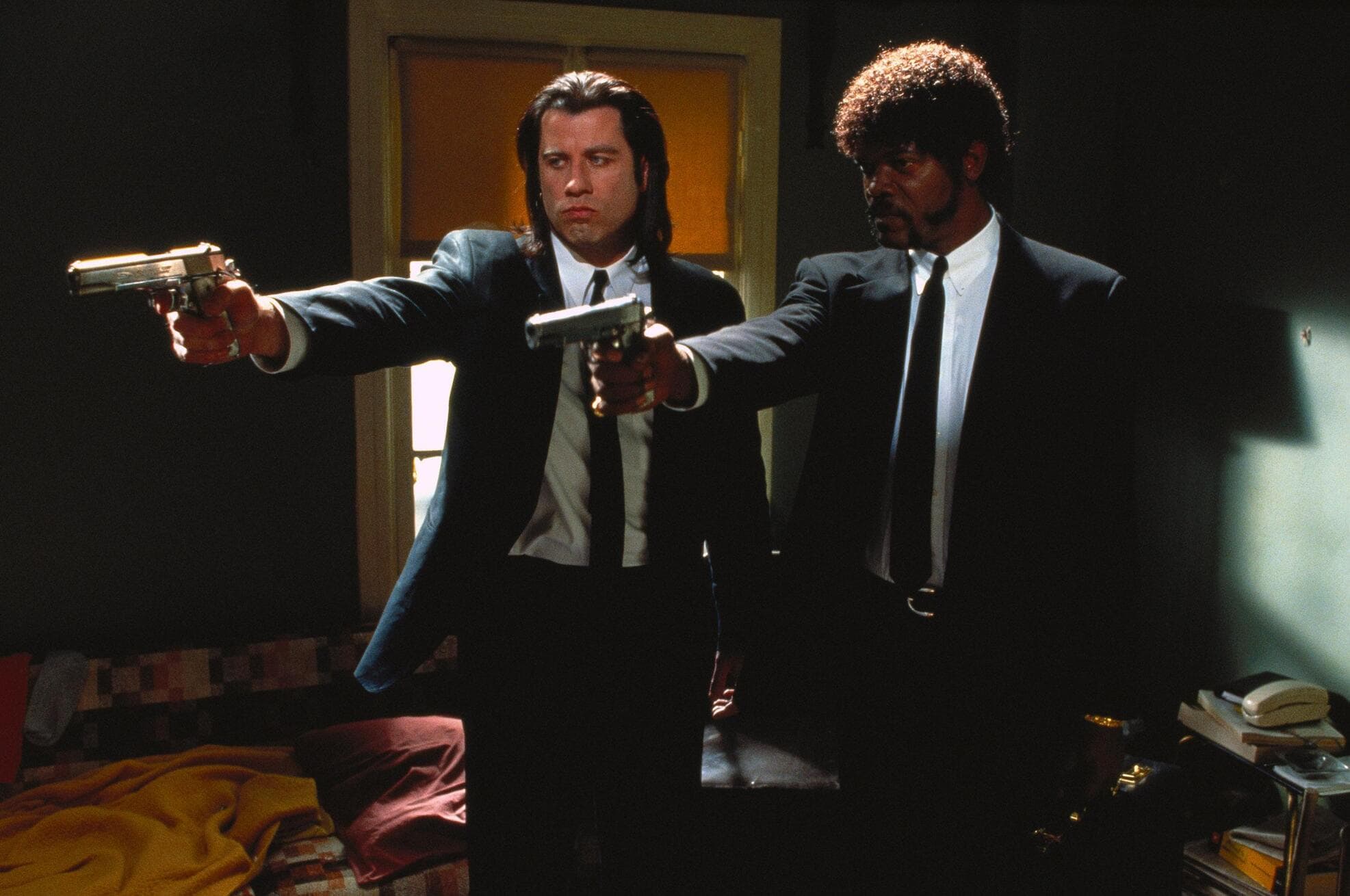 Two men in suits pointing their guns at someone off-screen in this image from A Band Apart.